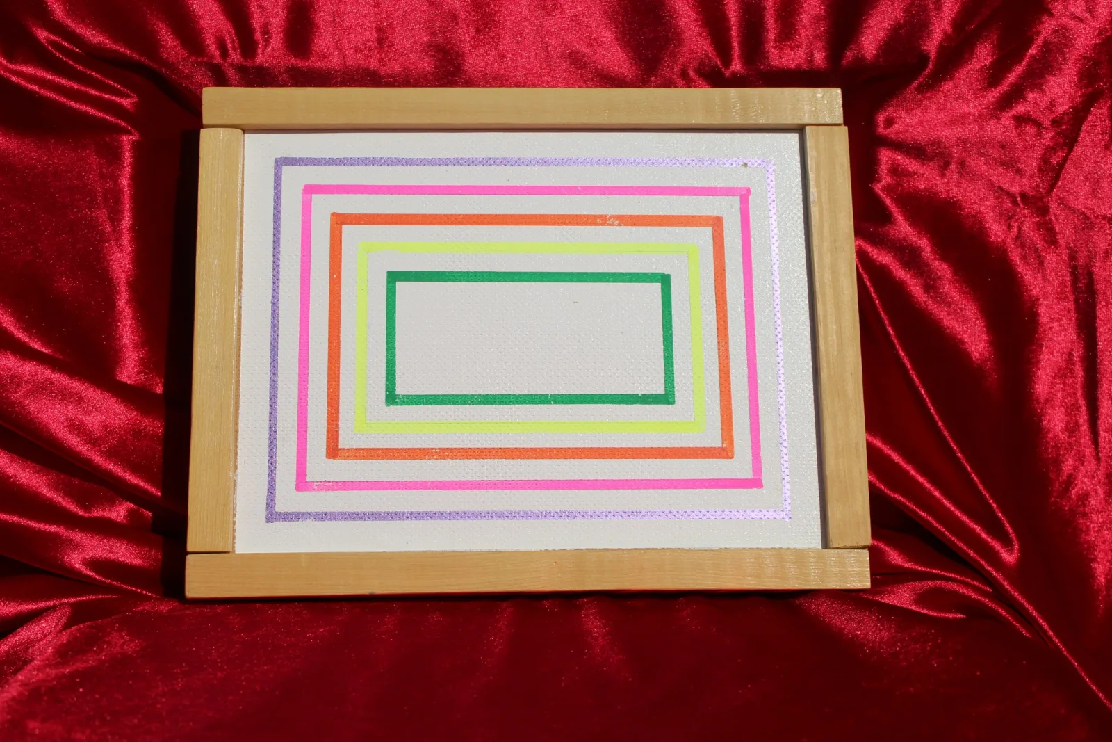 Casse-tête rectangulaire à motif de cadres concentriques multicolores, sur tissu rouge