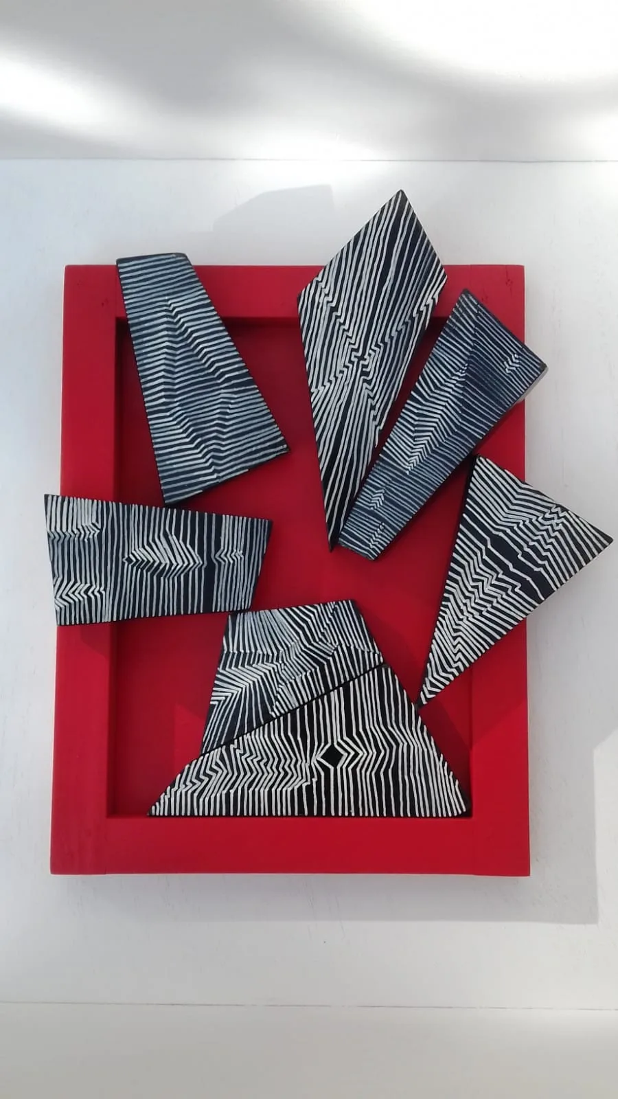 Casse-tête Le vasarely : pièces géométriques à rayures noires et blanches dans un cadre rouge